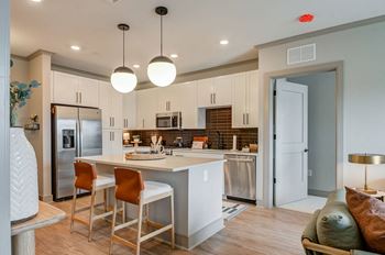 A kitchen with a center island next to a living room